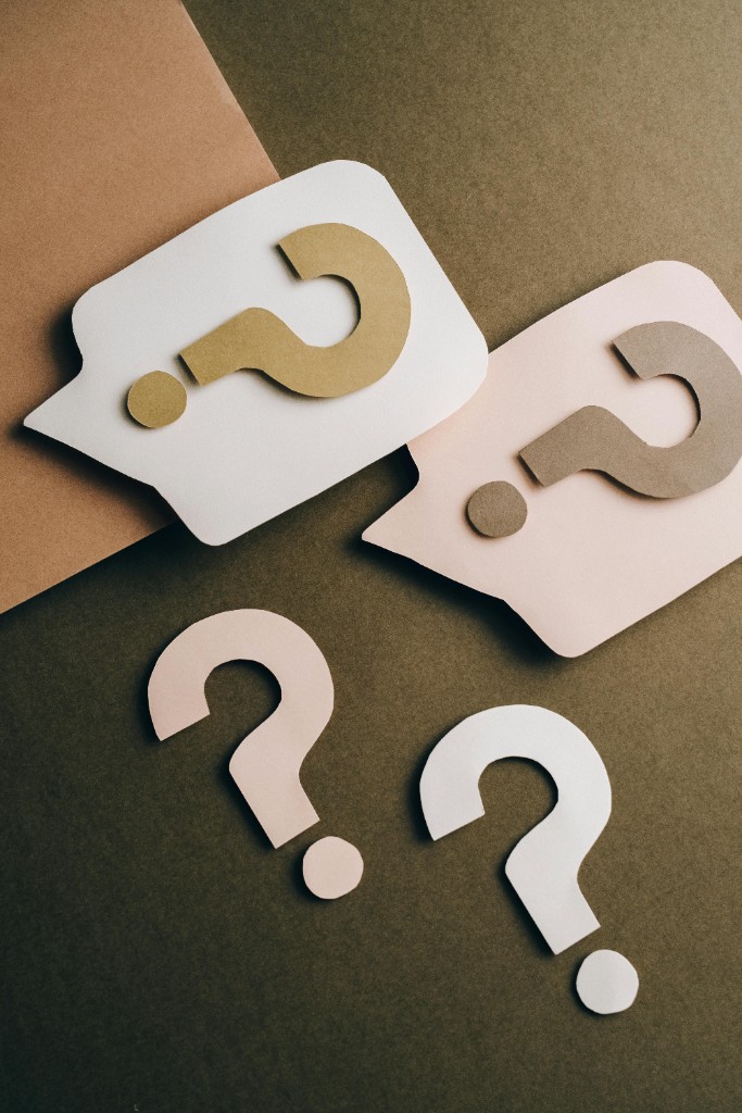 Paper speech bubbles and question marks